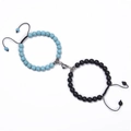 Close-up of sky blue and black beaded couple bracelets with heart-shaped magnetic clasp - Turquoise + Matte Stone