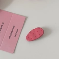 Dettaglio di un fermaglio per capelli ovale a pois rosa con finitura in resina liscia e lucida - Rosa Rossa