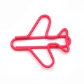 Pink airplane-shaped paper clip made of premium coated metal wire on white background - Pink