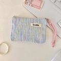 Detail einer hellblauen Stricktasche mit bunten Streifen und rosa Webschlaufe - Blau