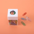 Dispenser magnetico per graffette con corpo trasparente e clip colorate su sfondo arancione - Con 18 Graffette / Bianco