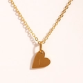 Détail d'un collier pendentif cœur doré avec la lettre I gravée sur fond blanc - Lettre I