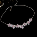 Dettaglio della collana con fiori in zircone rosa e cristalli luminosi su sfondo nero - Collana - Argento - Rosa