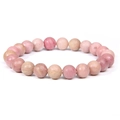 Natural pink stone beaded bracelet with polished round gemstones on a plain white background - Red Veined Stone