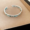 Detailed macro view of ethnic silver bangle featuring colorful inlaid turquoise and stones - Silver Hammered Texture Turquoise Style