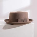 Détail d'un chapeau Pork Pie en laine marron avec ruban gros-grain et nœud latéral - Camel