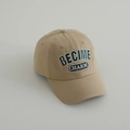 Dettaglio del cappello beige in cotone con ricamo verde 3D della scritta BECIME CHARM - 54cm 3-8 Anni / Cachi