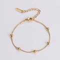 Dettaglio di un bracciale a sfere in acciaio inossidabile dorato con chiusura a moschettone - Oro