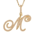 Macro shot of gold-plated letter M pendant featuring micro-paved sparkling cubic zirconia - M (Gold)