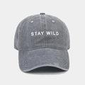 Détail de la broderie Stay Wild blanche sur la casquette en coton gris délavé - Réglable / Gris