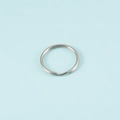 Macro shot of single silver stainless steel split key ring on light blue background - Steel