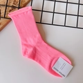 Detailed close-up of pink cotton blend crew sock with ribbed cuff and paper brand tag - One Size / Fluorescent Pink