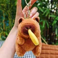 Cute capybara plush keychain with yellow banana accessory and silver metal ring - Eating Fries