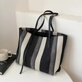 Vertical black and white striped tote bag with leather handles in a minimalist setting - Grey White Swirl