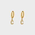 Close-up of gold-plated hoop earrings with sparkling zircon-studded letter C pendants - Letter C