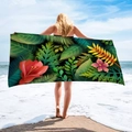 Detail of microfiber beach towel featuring vibrant tropical floral and palm leaf patterns - Red Hibiscus Leaf