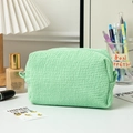 Macro detail of seersucker textured light green makeup bag with zipper closure - Green