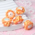Detail of five handmade orange and yellow acrylic DIY beads with iridescent centers - Sweet Orange + White Heart