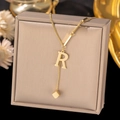Close-up of golden letter R pendant necklace with square charm on jewelry box - Letter R-Gold