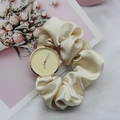 Champagne silk scrunchie watch strap with golden case against elegant floral background - Off White