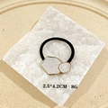 Macro shot of gold geometric hair cuff with white marble inlay on a beige tray - Enamel Marble White