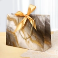 Elegant marble pattern paper gift bag featuring a golden rope handle and a large satin bow - XS (19x15x7cm) / Gilded Black (Marble)