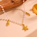 Dettaglio di ciondoli a stella marina e conchiglia dorati su collana di perle - Collana di Perle Con Stella Marina(H602)