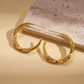 Macro detail of 18k gold-plated C-shaped twist earrings with micro-paved cubic zirconia - Real Gold Plated / Silver Pin - Gold - Medium