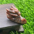 Dragon head carving made of natural red and green gemstone on a wood stand - Red Sesame