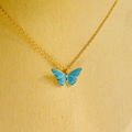 Elegante goldene Halskette mit blauem Schmetterlingsanhänger und Perlendetails - Schmetterlingskette