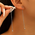 Close-up of silver sun-shaped long tassel earrings with metallic bead details on a model - Silver Sun Long Tassel Drop Earrings (0578)