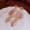 Detailed macro view of vintage gold drop earrings with purple faceted crystals - Gold Irregular Inlaid Purple Gemstone Style