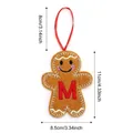 Plush brown gingerbread man ornament with red letter M and white wave embroidery - Style M