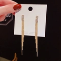 Close-up of golden geometric earrings with sparkling tassels and rhinestone details - Gold Stepped Pave Long Tassel Style (A28 Gold)