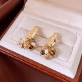 Detailansicht der Vintage-Perlenohrringe mit Gold-Finish in einer cremefarbenen Samtbox - Goldene Cluster-Perle Quasten-Stil mit Silbernadel