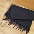 Soft black mohair scarf with tassels folded on a vintage leather chair for winter warmth - Black
