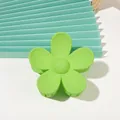 Detail of green matte flower hair claw clip with minimalist five-petal design on desk - Matte Large Flower - Grass Green
