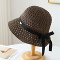 Détail d'un chapeau de soleil marron tissé avec ruban noir et logo en métal doré - Marron