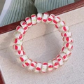 Spiral telephone cord hair tie featuring red strawberry patterns on a translucent base - Strawberry