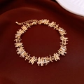 Detail of bamboo style gold bracelet with square cubic zirconia on red silk fabric - Bracelet - Gold