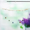 Handmade wind chime with seven colorful natural crystal stones on a light wood branch - Crushed Stone Style