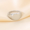 Makroaufnahme eines polierten Siegelrings aus Edelstahl auf champagnerfarbenem Seidenstoff - US 6 / 12mm Stahl (KR104688-K)