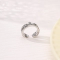 Silver-colored sun and moon crossover ring with sparkling crystals on beige background - Crisscross Zirconia Style