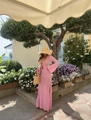 Elegant pink knit long dress with cut-out waist and flared sleeves in a outdoor garden - Pink