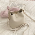 Sac seau minimaliste blanc crème avec logo MACCHEE et détails dorés sur literie blanche - Blanc