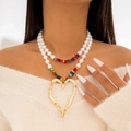 Close-up of double-layer necklace featuring white pearls and a gold open heart pendant - Multicolor (Layered Pearl Colorful Stone Heart)