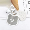 Dettaglio del portachiavi a specchio a forma di orso con targhetta a cuore e campanello - Bianco