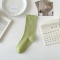 Light green cotton mid-calf sock shown in a minimalist flat lay with aesthetic props - Fruit Green