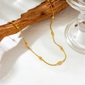 Minimalist gold stainless steel long bead chain necklace displayed on natural wood - Gold Egg Bead Necklace