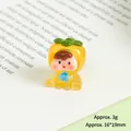 Macro shot of 16x19mm mini resin fruit doll figure weighing 3g on a book page - Luminous Persimmon